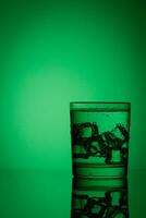 hermosa vaso con hielo y agua en un verde antecedentes foto