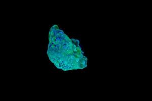 macro mineral stone opal under ultraviolet light on a black background photo