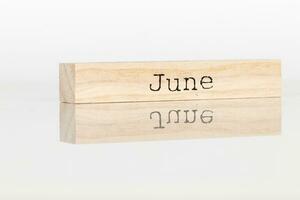 a wooden cube with the inscription June on a white background photo