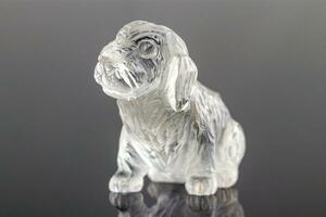 beautiful statuette of a dog from the mineral topaz on a gray background photo