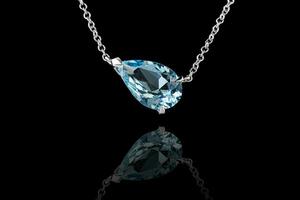 beautiful pendant aquamarine in gold with a chain on a black background photo