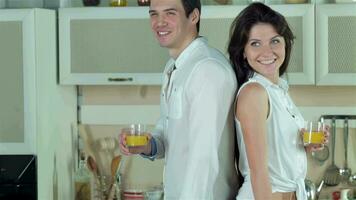 Newly married couple standing back to back holding orange juice video