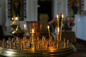 Church candles burn in a candlestick against the backdrop of icons photo