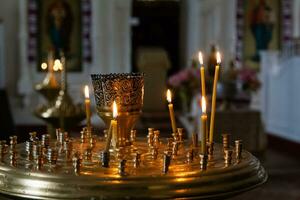 Church candles burn in a candlestick against the backdrop of icons photo