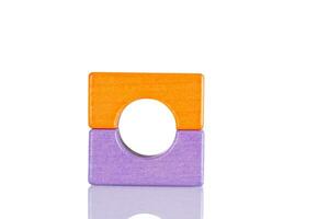 Wooden figurine of purple and orange color on a white background photo