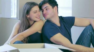 casal sentado em a chão entre a caixas e beijo video