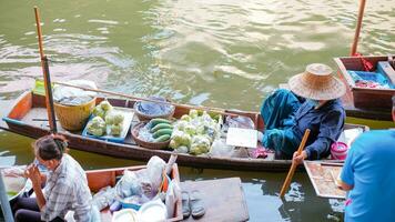 Ratchaburi City, RB, 2022- Group of boat selling Thai fruit and food at ancient travel destination of Thailand Damnoen saduak flating market, Ratchaburi Thailand. photo