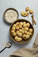 Puff pastry eyelet, Palmier cookies in a bowl with cinnamon and sugar on the light concrete background. Top view. photo