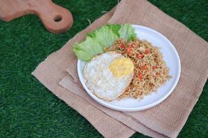 indonesian spicy noodles with egg on white plate. stock photo