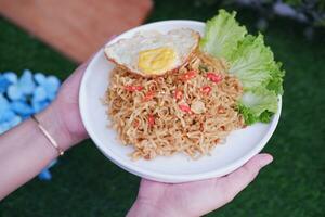 indonesian spicy noodles with egg on white plate. stock photo