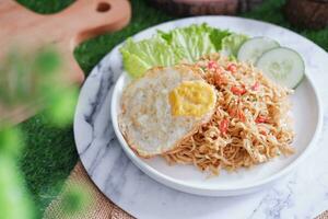 indonesian spicy noodles with egg on white plate. stock photo