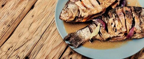 Tasty baked fish on plate photo