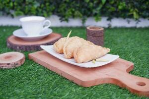 Curry puff or Pastel Goreng is Pastry Popular in Indonesia. fried pastry with filling of sauted vegetable, chicken and boiled egg. accompanied with  sauce or raw chilli pepper photo
