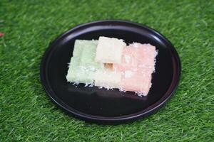 Getuk lindri, traditional food from Java Indonesia against grass background photo