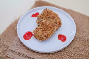 Crispy fried chicken on a plate with sauce, stock photo