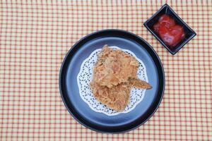 crujiente frito pollo en un plato con salsa, valores foto