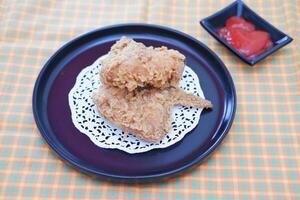 Crispy fried chicken on a plate with sauce, stock photo