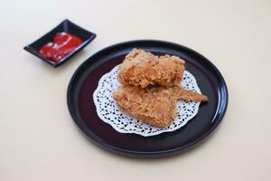 Crispy fried chicken on a plate with sauce, stock photo