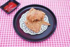 Crispy fried chicken on a plate with sauce, stock photo