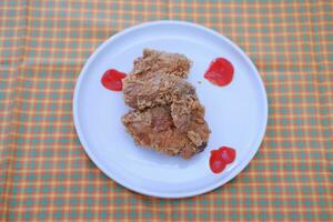 Crispy fried chicken on a plate with sauce, stock photo