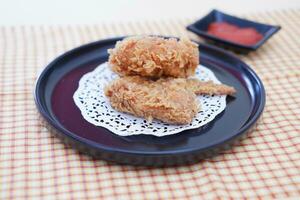 Crispy fried chicken on a plate with sauce, stock photo