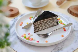 Piece of homemade chocolate crepes cake on a white plate photo