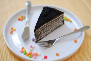 Piece of homemade chocolate crepes cake on a white plate photo