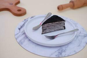Piece of homemade chocolate crepes cake on a white plate photo