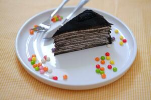 Piece of homemade chocolate crepes cake on a white plate photo