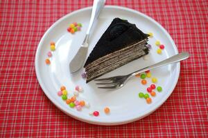 Piece of homemade chocolate crepes cake on a white plate photo