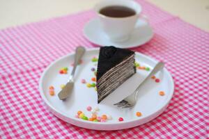 Piece of homemade chocolate crepes cake on a white plate photo