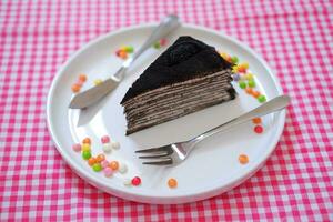 Piece of homemade chocolate crepes cake on a white plate photo