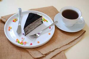 Piece of homemade chocolate crepes cake on a white plate photo