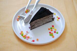 Piece of homemade chocolate crepes cake on a white plate photo