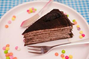 Piece of homemade chocolate crepes cake on a white plate photo