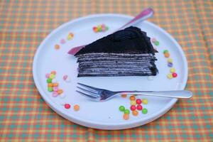 Piece of homemade chocolate crepes cake on a white plate photo