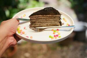 Piece of homemade chocolate crepes cake on a white plate photo
