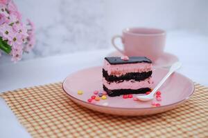 Piece of chocolate cake on pink plate as a background photo