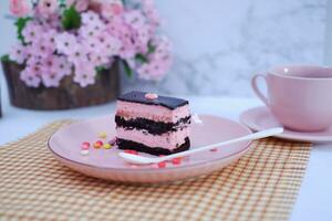 Piece of chocolate cake on pink plate as a background photo