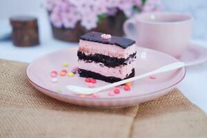 pedazo de chocolate pastel en rosado plato como un antecedentes foto
