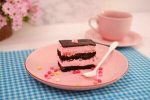 Piece of chocolate cake on pink plate as a background photo