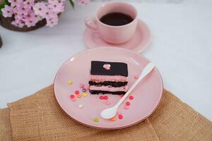 Piece of chocolate cake on pink plate as a background photo