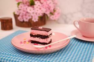 pedazo de chocolate pastel en rosado plato como un antecedentes foto