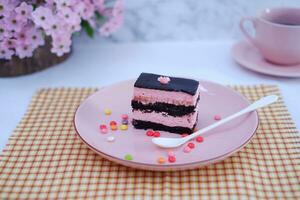 pedazo de chocolate pastel en rosado plato como un antecedentes foto