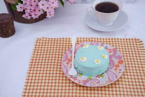 Green tea mousse cake with cup of coffee on the table. photo