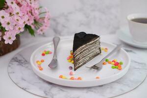 Piece of homemade chocolate crepes cake on a white plate photo