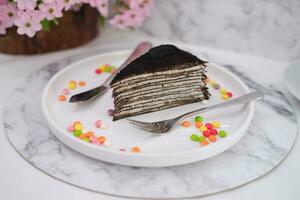 Piece of homemade chocolate crepes cake on a white plate photo