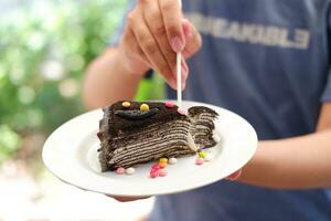 Piece of homemade chocolate crepes cake on a white plate photo