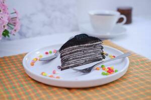 Piece of homemade chocolate crepes cake on a white plate photo