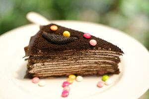 Piece of homemade chocolate crepes cake on a white plate photo